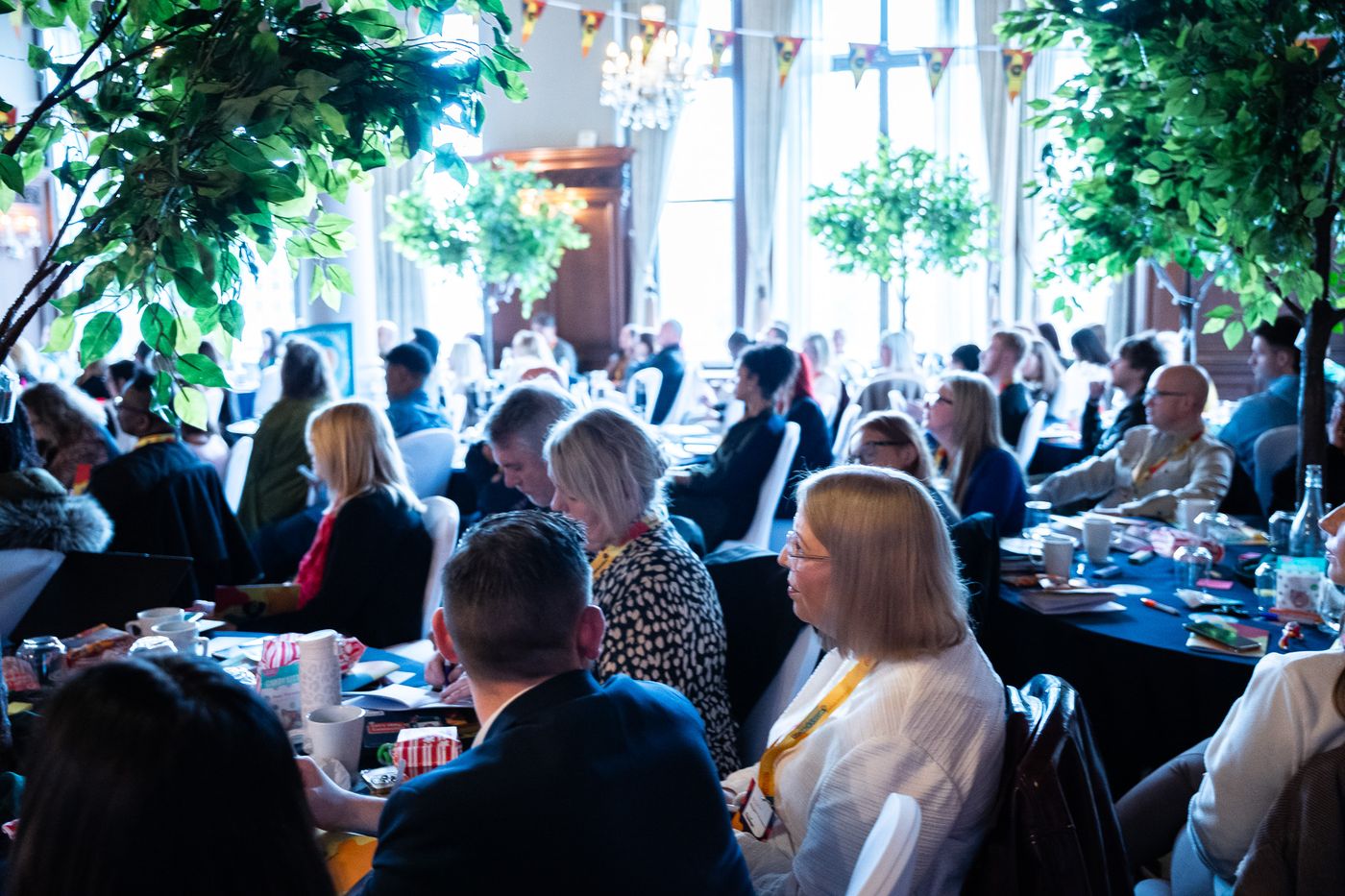 Delegates at round tables listening to a keynote