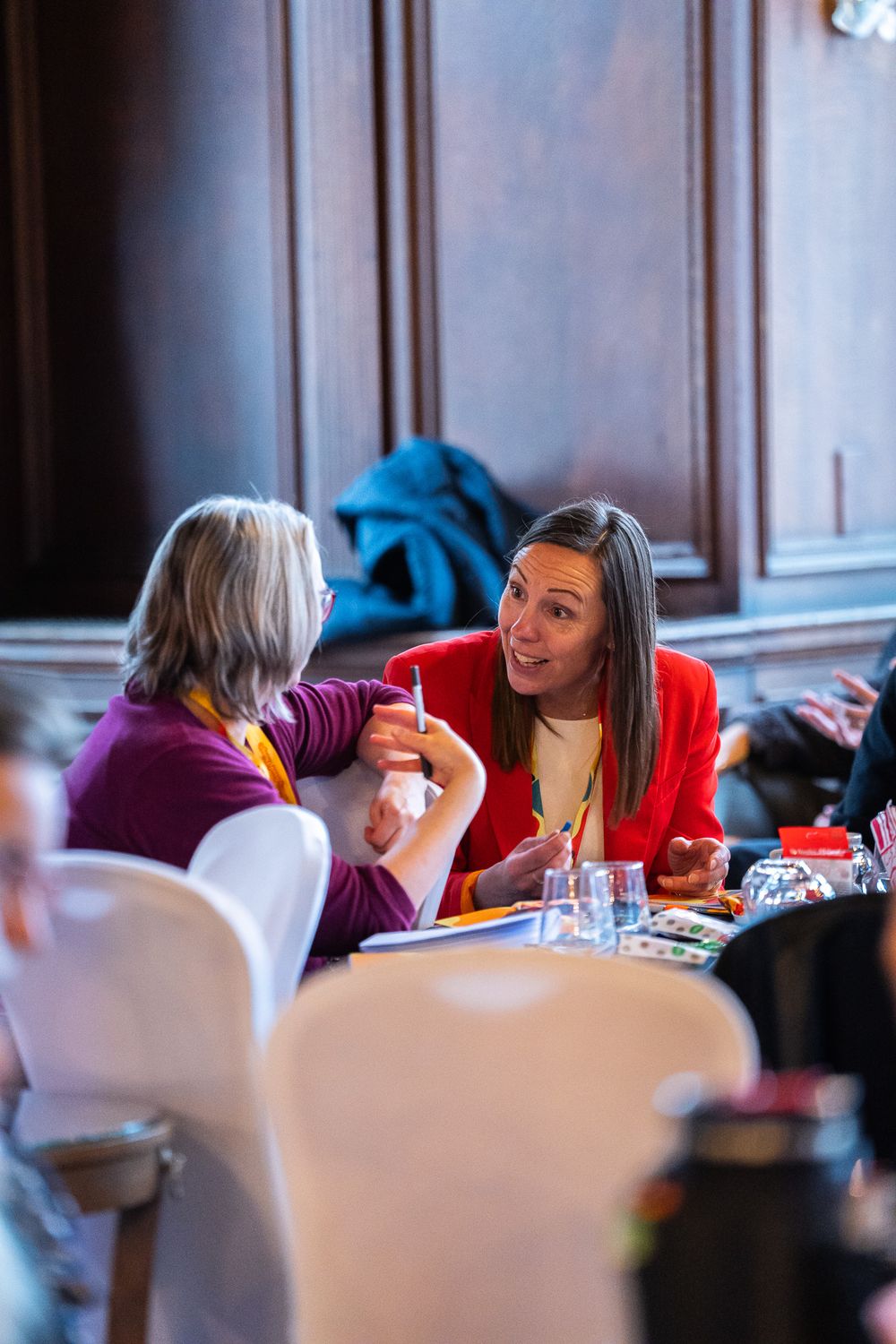 Two delegates in conversation at a table